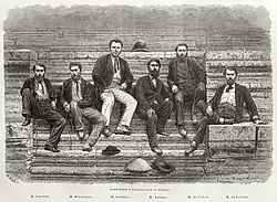 Une gravure représentant six hommes habillés à l'occidentale, assis sur un escalier ancien en pierre