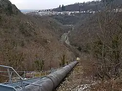 Photographie prise en plongé de la conduite forcée partant de la Durolle et montant jusque dans la montagne.