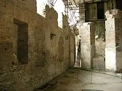 Mur de l'exèdre donnant sur le portique, creusé d'ouvertures et de niches.