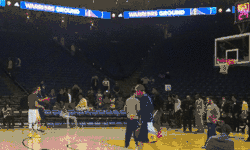  Stephen Curry, à gauche, en short blanc, effectuant un tir à trois points lors de la préparation d'une rencontre NBA en 2015.