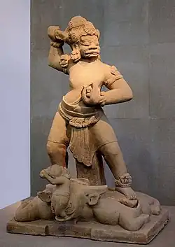 Dvarapala piétinant un taureau, lequel crache un petit personnage. Grès. Fin IXe - début Xe&nbsp;siècle.MNH Vietnam