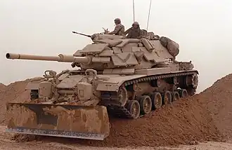 Un char de combat M60A1 du 2ème bataillon de chars des Marines durant l'opération Tempête du désert, il est recouvert d'un surblindage AAS (Appliqué Armor System) fait de tuiles réactives explosives M1 et M2.