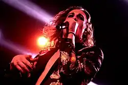 Photographie de Damiano David, chantant en concert en 2018.