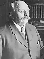 Photographie en noir et blanc et en buste d'un homme vêtu d'un costume.