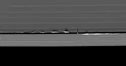 « Vagues » verticales provoquées par Daphnis projetant leurs ombres dans les anneaux de Saturne.