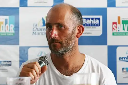 Portrait, barbu, de trois quarts, micro en main.