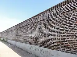 Le mur d'enceinte subsiste dans la partie sud-ouest du carreau.
