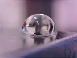 Photographie rapprochée d'une goutte sur une feuille tendue de PDMS.