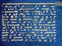 Photographie d’un feuillet du Coran bleu, conservé au musée national du Bardo. Écrit en coufique doré sur du vélin teint à l’indigo, il provenait à l’origine de la bibliothèque de la Grande Mosquée de Kairouan.