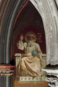 Un jeune homme barbu en toge avec une auréole est debout devant une croix tandis que deux hommes barbus portant également une auréole sont à ses pieds.