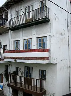 Une image d'un bâtiment robuste avec des images imprimées de fenêtres au lieu de verre réel avec des rideaux et des encadrements.