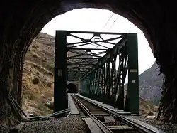 Au premier plan, entrée du tunnel et au second plan au centre le pont ferroviaire vert