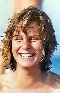 Photographie couleur d'une jeune femme blanche, de face, rieuse, cheveux mouillés