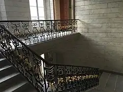 Vue de l'escalier d'honneur avec son garde-corps en fer forgé