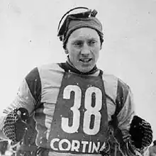 Photographie en noir et blanc d'un athlète portant un dossard marqué de l'inscription Cortina et du numéro 38.