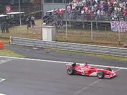 Photo d'une voiture rouge roulant sur une ligne droite.