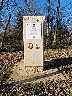 Monument vertical de forme parallélépipédique en pierre calcaire, ornée d'une plaque et de photographies en médaillons d'Andrée Borrel et Marie-Lise de Baissac