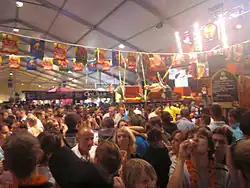 Un hall plein de monde, avec des buvettes.