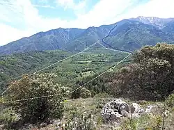 Cône de déjection, commune de Fillols - son étendue approximative est indiquée par la ligne blanche hachurée. La ligne bleue représente le cours actuel de la rivière Fillols.