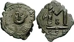 Photographie des deux faces d'une pièce en bronze représentant un personnage et une croix.