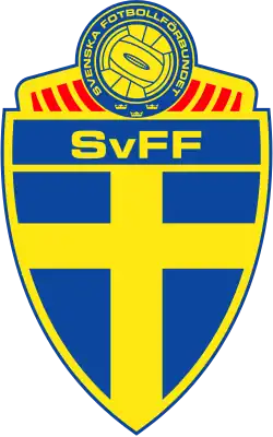 Armoiries de la Fédération suédoise. Une scandinave jaune sur fond bleu en forme de bouclier surmonté d'un ballon jaune et bleu.