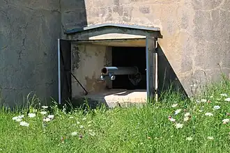 Un créneau de tir avec son canon en position au fort d'Uxegney.