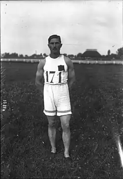 Portrait en pied noir et blanc d'un athlète en tenue de sport, debout les mains dans le dos