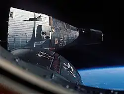 Photographie couleur du vaisseau Gemini 7 en orbite prise depuis un autre vaisseau.