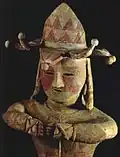 Haniwa d'homme en chapeau à clochettes, jambes croisées, armé, pigment rouge (h. 91 cm). Iwaki, Fukushima, VIe siècle (?), Iwaki High School