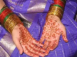 Mains d'une jeune mariée indienne décorées au henné.