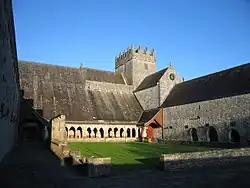 Photographie d'un cloître presque entièrement conservé et dominé par une église intacte
