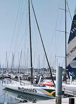 Vu de trois quarts avant, voilier blanc amarré au ponton.