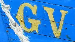 Gros plan sur lettres GV précédant le numéro d'immatriculation d'un petit bateau