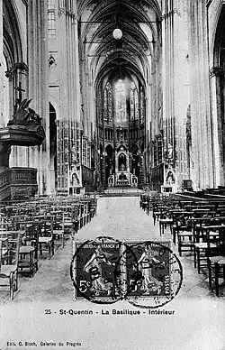 Église en pierre à hautes voûtes avec, à gauche, une chaire, et, en arrière-plan, un autel. Certains murs sont peints, (photo noir et blanc).