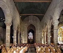 Photographie d'un intérieur d'église avec une nef séparée du transept par un arc triomphal imposant