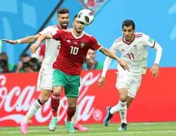 Belhanda protégeant son ballon face à Ramin Rezaeian et Vahid Amiri.