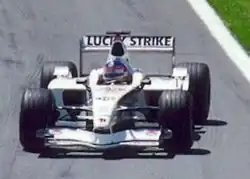 Photo d'une monoplace blanche sur une piste, éblouie par le soleil