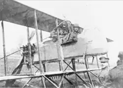 Photographie noir et blanc de deux hommes assis dans un biplan.