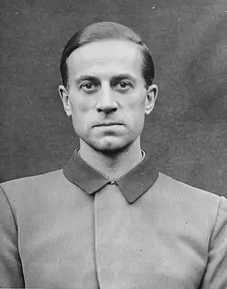 Photo noir et blanc (format photo d'identité, en buste, de face) de Karl Brandt, médecin SS de Hitler. L'homme porte une veste claire au col foncé fermé.