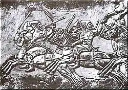 Bas-relief montrant des cavaliers au galop.