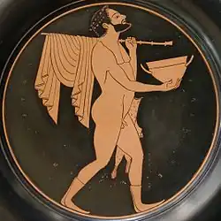 Comaste portant un skyphos, un bâton où s'enroule une draperie et un étui à flûtes, assiette à figures rouges, Paris, Bibliothèque nationale de France, Cabinet des médailles.