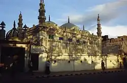 Bâtiment avec des coupoles et des minarets, photographié depuis une rue.