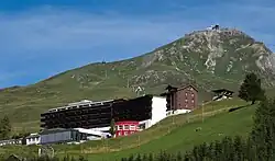 Bâtiment sur les flancs d'une montagne en été.