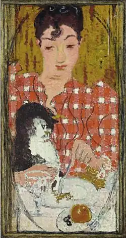 Tableau en hauteur montrant en gros plan une femme en corsage à carreaux rouges et blancs, attablée avec un chat, l'air un peu désabusée.