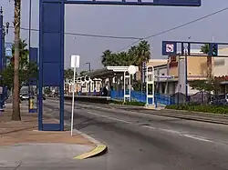 Vue de loin du quai, et des colonnes de l'artiste. On voit également des palmiers.