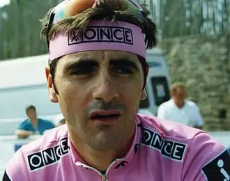 photo couleur d'un sportif à maillot rose marqué ONCE. les mêmes remarques s'appliquent au bandeau tour de tête.