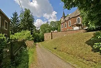 Photographie d'un village, au milieu une route, à droite une église.