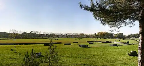 Photo panoramique d'un hippodrome verdoyant.