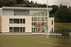 un bâtiment blanc derrière une pelouse