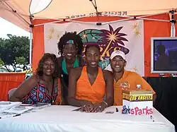 Lisa Leslie avec deux autres personnes, une troisième debout derrière elle.